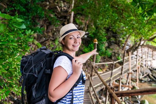 tourist with a backpack shows the direction of the route