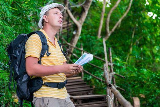 man tourist lost, check with map and terrain in the hike