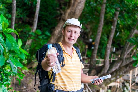 young tourist man giving a bottle of water