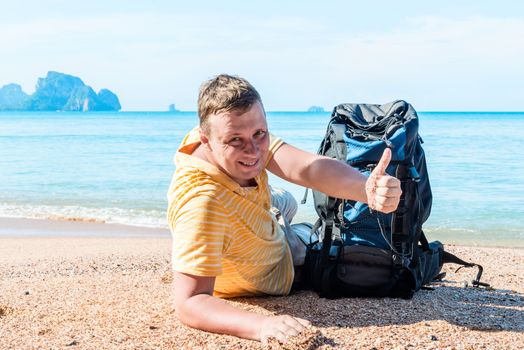 happy traveler with a backpack got to the sea, portrait on the beach