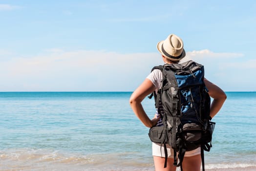 woman tourist with a backpack admiring the beautiful scenery of the sea