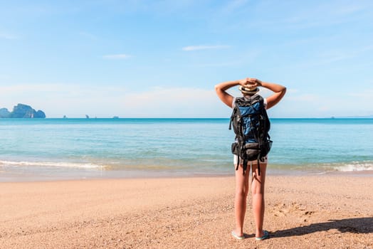 woman tourist enjoys relaxing on the beach after a long hike