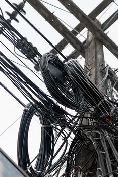 picture of a close-up of randomly hanging wires on electric poles in Thailand