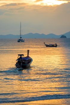 Thai wooden boats in the rays of the setting sun vertical photography