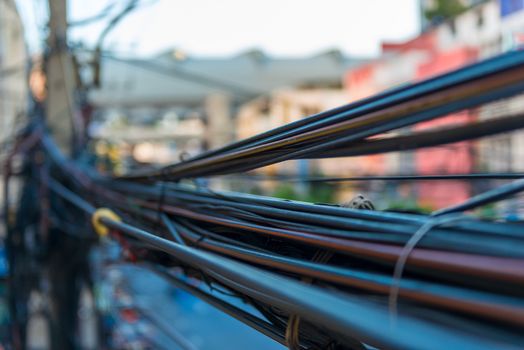closeup randomly hanging wires on electric poles in Thailand