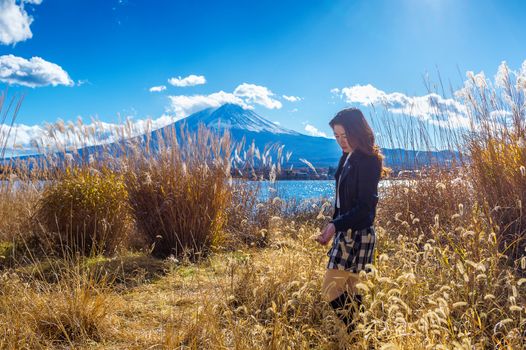 Beautiful girl standing at kawaguchiko lake with view of Fuji mountain, Autumn in Japan.