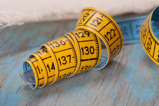 Retro sewing accessories - tape measure and threads on blue background