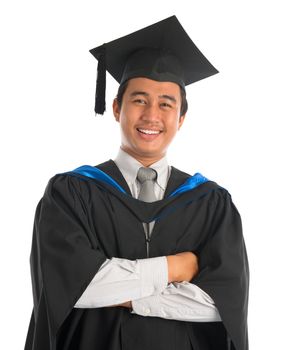 Waist up happy Asian male university student in graduation gown smiling, isolated on white background. Good looking Southeast model.