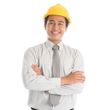 Portrait of attractive Southeast Asian engineer with yellow hard hat arms crossed smiling, standing isolated on white background.