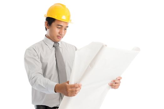 Portrait of attractive Southeast Asian engineer with yellow hard hat and blue prints, standing isolated on white background.