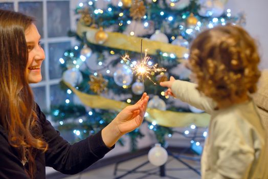 Teen girl holding sparklers and children