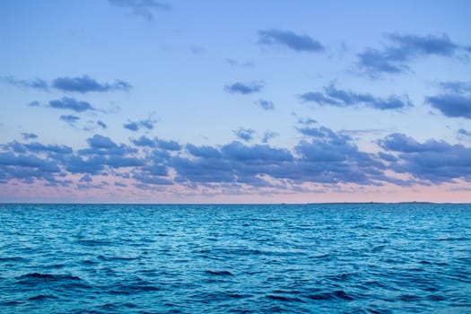 Sunset sunrise in open sea with dramatic cloudy calm clear sky