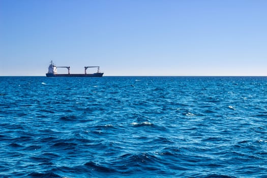 Open sea view on sunny day to longly ship