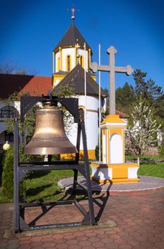 Bell and cross in front of church, Privina Glava, Serbia