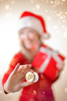 Sydney, Australia - December 17, 2017;  Using cryptocurrency to buy gifts and presents at Christmas.  A woman is holding a bitcoin and a litecoin in her hand and smiling,