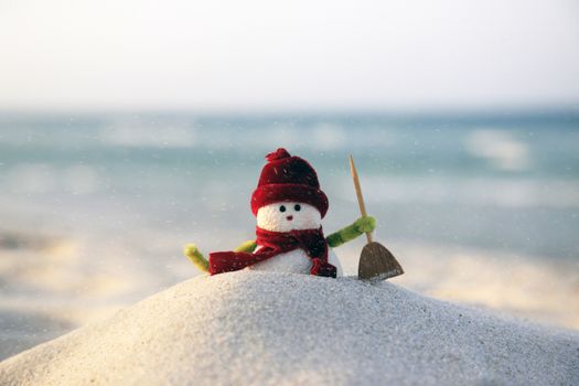 Toy of the snowman on beach background