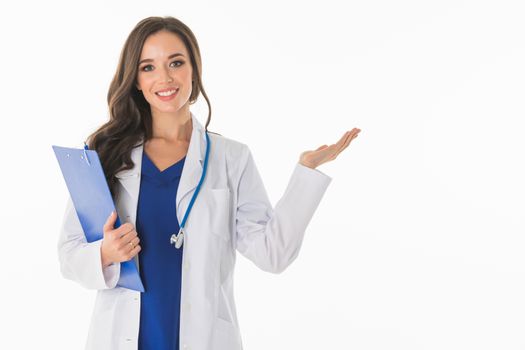 Portrait of happy smiling young female doctor showing something or blank area for text, or copyspace, isolated over white background