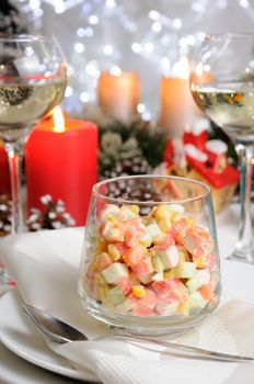 Salad of cubes of crab meat and vegetables dressed with yogurt in a glass on the Christmas table