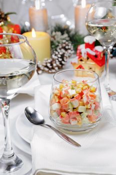 Salad of cubes of crab meat and vegetables dressed with yogurt in a glass on the Christmas table