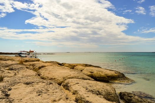 View From the sandy beach of Elafonisi with a small fishing boat in the west of the island of Crete