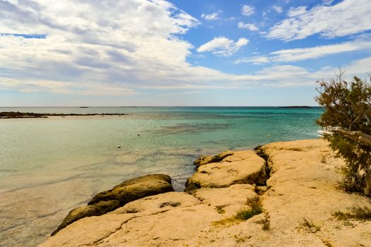 View From the sandy beach of Elafonisi with a small fishing boat in the west of the island of Crete