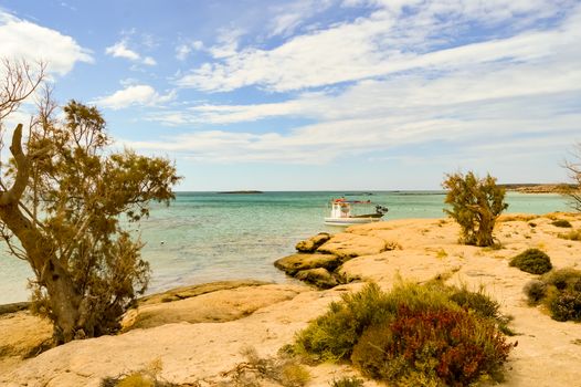 View From the sandy beach of Elafonisi with a small fishing boat in the west of the island of Crete