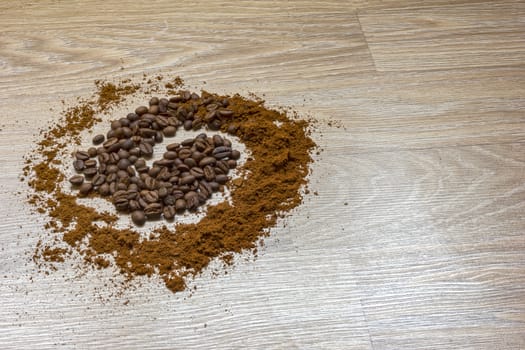 Coffee beans and ground coffee on a wooden table like a spiral.  Style concept