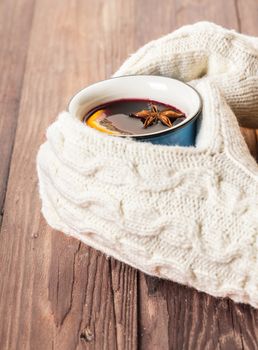 female hands in gloves holding hot mulled wine