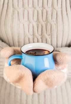 female hands in gloves holding hot mulled wine