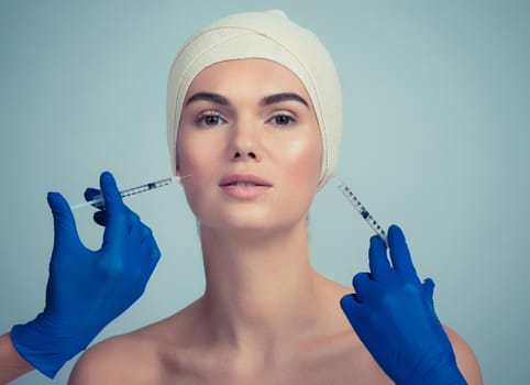 Attractive young woman gets cosmetic injection. Doctors hands making an injection in face. Beauty Treatment.