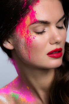 Beauty portait of woman with many color glitters over natural makeup