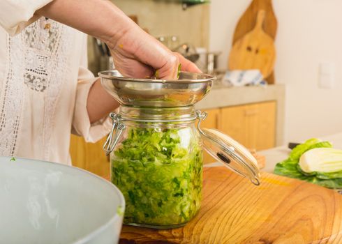 Preparing fermented preserved vegetables. Jars of cabbage kimchi and sauerkraut sour cabbage. 
