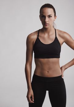 Portrait of sporty young woman with muscular body looking at camera