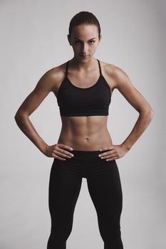 Portrait of sporty young woman with muscular body looking at camera