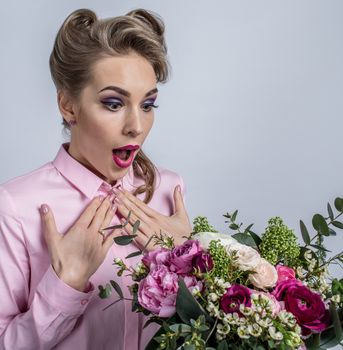 Woman surprised with bunch of flowers, funny emotional expression