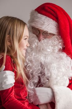 Portrait of smiling little girl sitting on santa claus knees