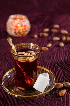 Tunisian tea in traditional glass with sugar cube and pine nuts
