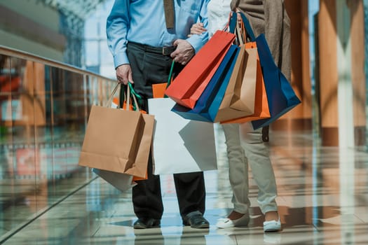 Adult senior couple with purchases in bags at shopping mall