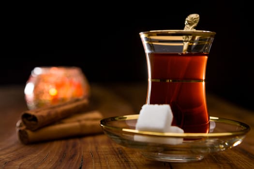 Closeup of Turkish tea in traditional glass over a wooden background in backlight