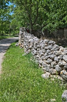 Stone fence beside road made of rocks