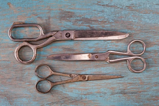 Retro sewing accessories - scissors on blue wooden background