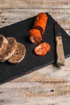 Malt loaf bread and chorizo slices on table.