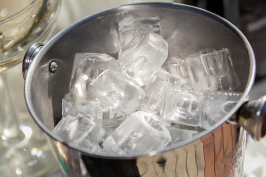 A bucket with ice cubes close-up, top view.