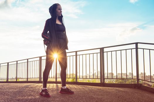 A woman in sportswear on evening city background