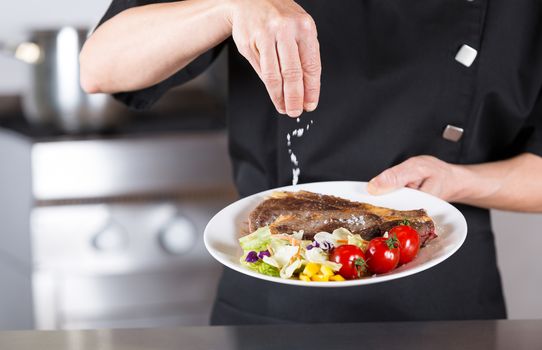 Chef finishing her plate and almost ready to serve at the table