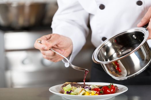 Chef finishing her plate and almost ready to serve at the table