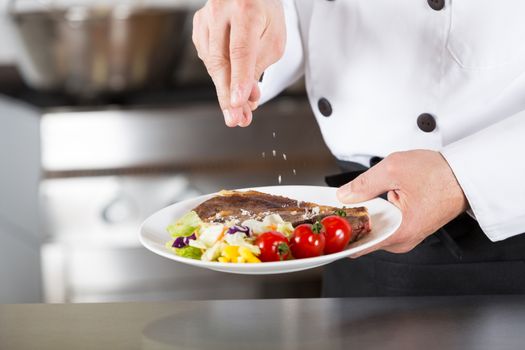 Chef finishing her plate and almost ready to serve at the table