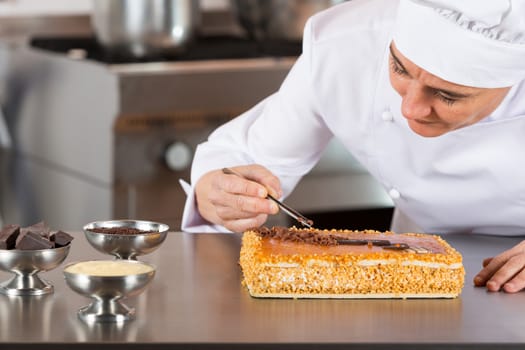 Pastry chef decorating cake yolk and cream