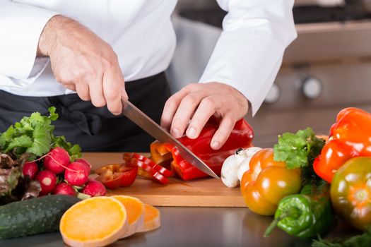 Chef cutting fresh and delicious vegetables for cooking