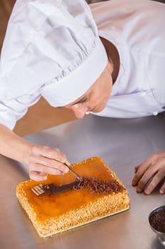Pastry chef decorating cake yolk and cream
